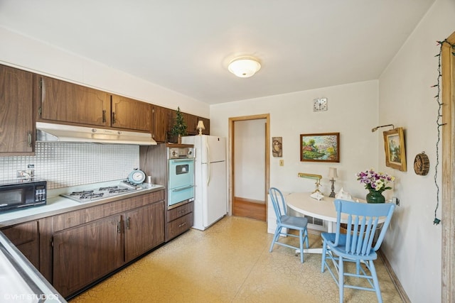 2555 Stratford Ave, Westchester, IL 60154 - kitchen featuring white appliances, under cabinet range hood, a warming drawer, backsplash, and light countertops
