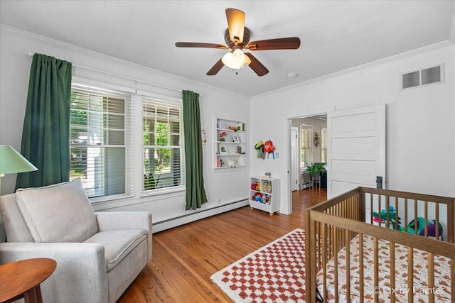 1020 S 4th St, Saint Charles, IL 60174 - bedroom featuring a baseboard radiator, crown molding, wood finished floors, a crib, and a ceiling fan