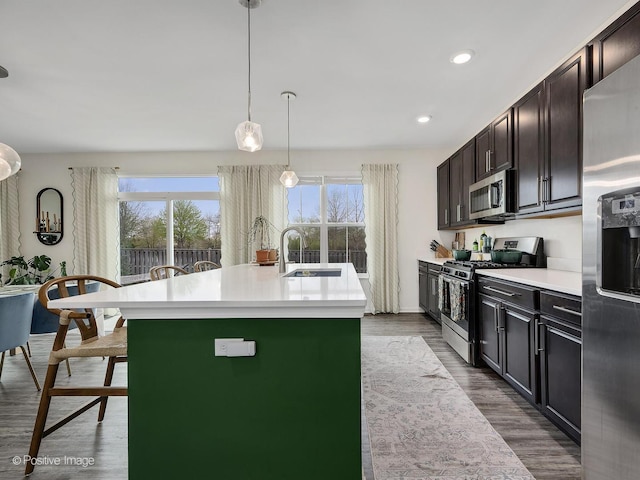 257 Kennedy Dr, Saint Charles, IL 60175 - kitchen with stainless steel appliances, light countertops, dark wood finished floors, a kitchen island with sink, and recessed lighting