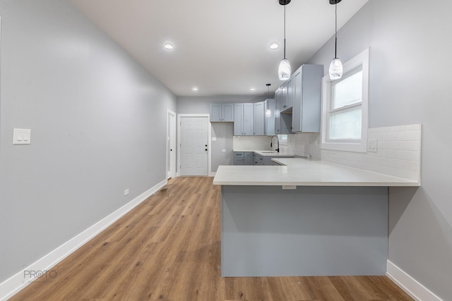 8007 S Avalon Ave, Chicago, IL 60619 - kitchen with gray cabinets, a peninsula, wood finished floors, backsplash, and recessed lighting