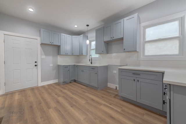 8007 S Avalon Ave, Chicago, IL 60619 - kitchen with gray cabinetry, decorative backsplash, light wood-style flooring, recessed lighting, and pendant lighting