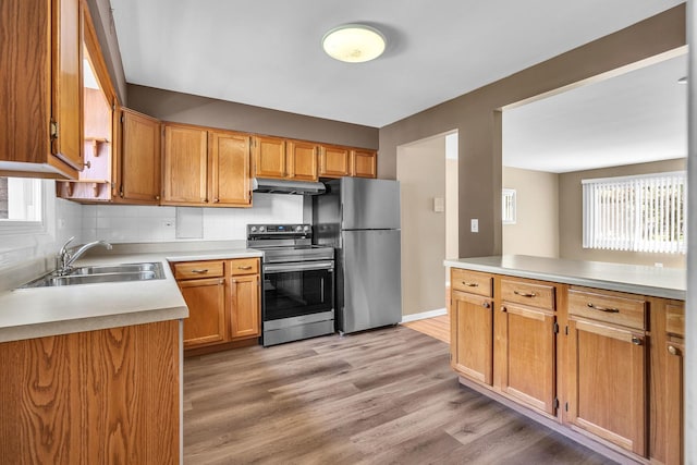 7952 Madison St Unit 2E, River Forest, IL 60305 - kitchen featuring stainless steel appliances, under cabinet range hood, light countertops, and light wood-style flooring