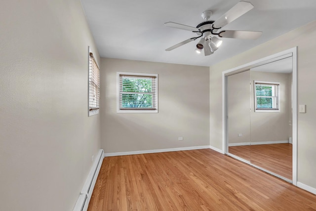 7952 Madison St Unit 2E, River Forest, IL 60305 - unfurnished bedroom featuring light wood-type flooring, a closet, a baseboard radiator, and a ceiling fan
