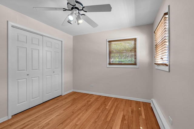 7952 Madison St Unit 2E, River Forest, IL 60305 - unfurnished bedroom featuring a baseboard radiator, light wood finished floors, a closet, and ceiling fan