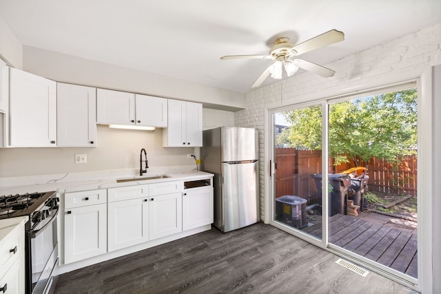3075 Kingston Ct, Streamwood, IL 60107 - kitchen featuring freestanding refrigerator, black gas stove, a ceiling fan, and white cabinetry