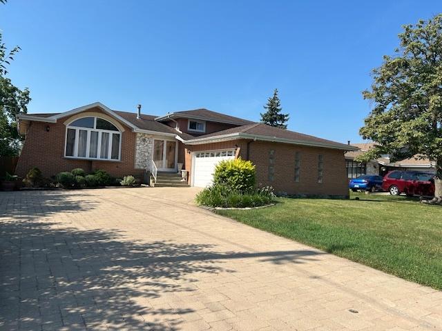 9842 S 88th Ave, Palos Hills, IL 60465 - tri-level home with decorative driveway, brick siding, a garage, and a front lawn