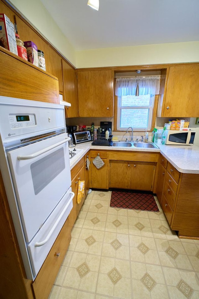 4444 N Central Ave Unit 2W, Chicago, IL 60630 - kitchen featuring white appliances, brown cabinets, light countertops, and extractor fan