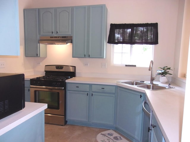 570 Windsor Dr Unit 570, Fox Lake, IL 60020 - kitchen featuring stainless steel gas range oven, under cabinet range hood, black microwave, light countertops, and blue cabinets