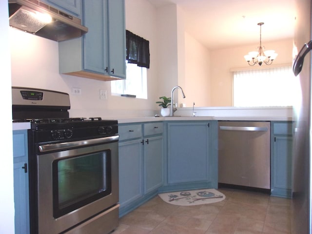 570 Windsor Dr Unit 570, Fox Lake, IL 60020 - kitchen with stainless steel appliances, under cabinet range hood, blue cabinets, and plenty of natural light