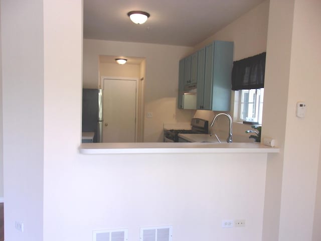 570 Windsor Dr Unit 570, Fox Lake, IL 60020 - kitchen featuring range with gas stovetop, freestanding refrigerator, and light countertops