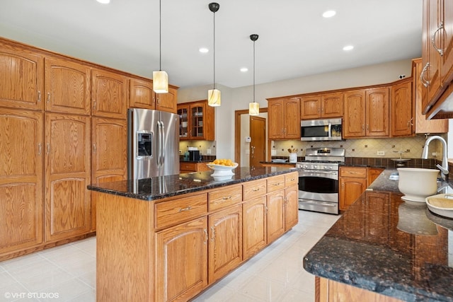 1600 Elderberry Dr, Libertyville, IL 60048 - kitchen featuring stainless steel appliances, a kitchen island, brown cabinets, dark stone countertops, and glass insert cabinets