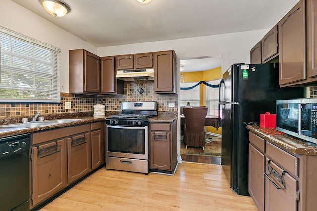 229 Ascot Ln, Streamwood, IL 60107 - kitchen featuring black appliances, under cabinet range hood, dark countertops, light wood finished floors, and tasteful backsplash