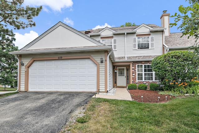 229 Ascot Ln, Streamwood, IL 60107 - view of front of property with asphalt driveway, brick siding, an attached garage, a chimney, and a front lawn
