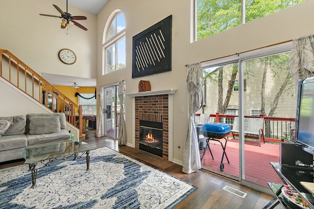 229 Ascot Ln, Streamwood, IL 60107 - living area featuring a towering ceiling, ceiling fan, wood finished floors, stairway, and a fireplace