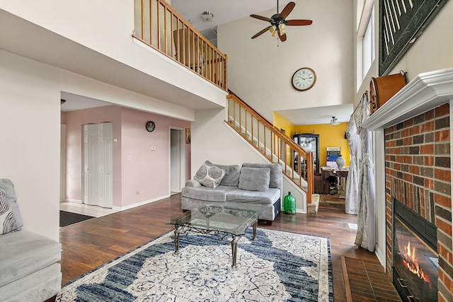 229 Ascot Ln, Streamwood, IL 60107 - living room featuring a brick fireplace, ceiling fan, stairs, a high ceiling, and wood finished floors
