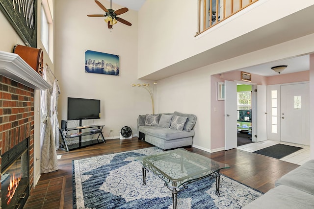 229 Ascot Ln, Streamwood, IL 60107 - living area with a fireplace, a ceiling fan, wood finished floors, and a high ceiling