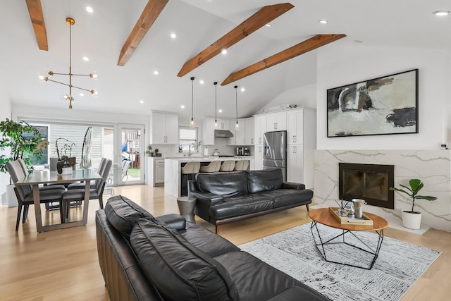 4944 Jarvis Ave, Skokie, IL 60077 - living room with beamed ceiling, light wood-type flooring, a chandelier, a fireplace, and high vaulted ceiling