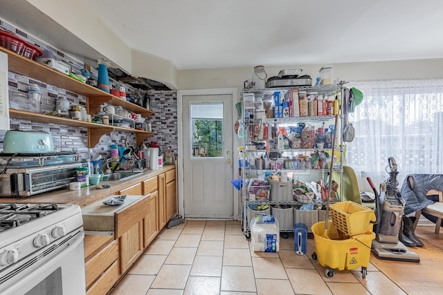 5228 W 54th St, Chicago, IL 60638 - kitchen with open shelves, light tile patterned floors, decorative backsplash, light countertops, and gas range gas stove