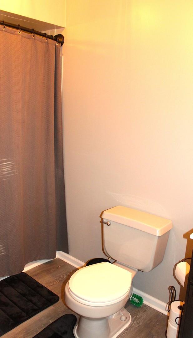 7926 S 83rd Ct, Justice, IL 60458 - bathroom featuring wood finished floors and a shower with curtain