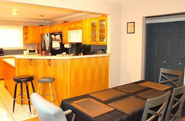 7926 S 83rd Ct, Justice, IL 60458 - kitchen with freestanding refrigerator, white microwave, a kitchen bar, open shelves, and light countertops