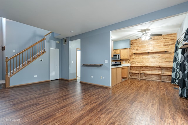 2517 Oak Tree Ln, Plainfield, IL 60586 - unfurnished living room featuring a ceiling fan, stairs, dark wood-style floors, and wooden walls