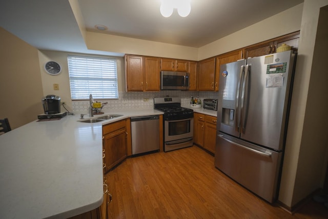 510 Orchards Pass, Bartlett, IL 60103 - kitchen featuring stainless steel appliances, light countertops, brown cabinets, light wood finished floors, and tasteful backsplash