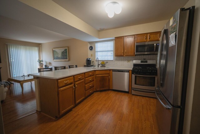 510 Orchards Pass, Bartlett, IL 60103 - kitchen with appliances with stainless steel finishes, a peninsula, brown cabinets, wood finished floors, and light countertops
