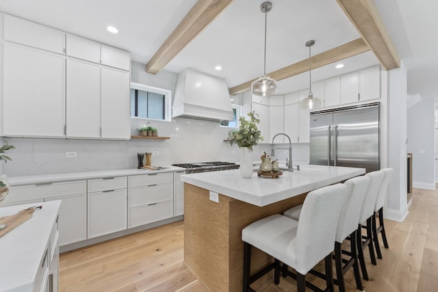 1100 Washington St, Glenview, IL 60025 - kitchen with custom exhaust hood, beam ceiling, backsplash, stainless steel appliances, and a kitchen bar