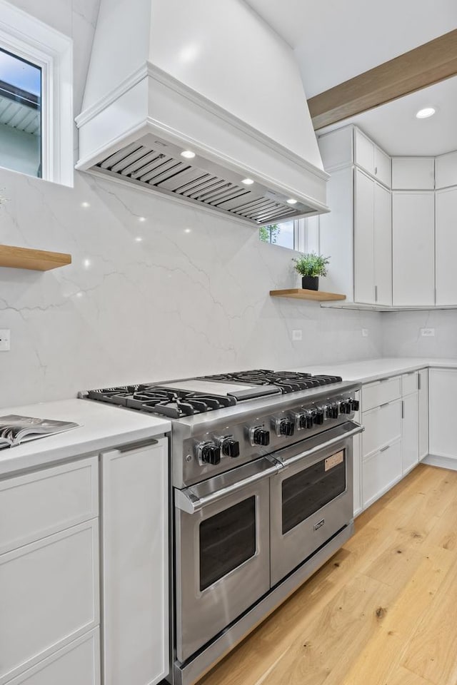 1100 Washington St, Glenview, IL 60025 - kitchen featuring custom range hood, double oven range, white cabinetry, light wood finished floors, and backsplash