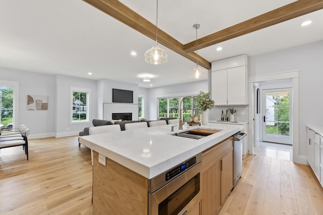 1100 Washington St, Glenview, IL 60025 - kitchen featuring recessed lighting, light wood-type flooring, a center island with sink, beamed ceiling, and light countertops
