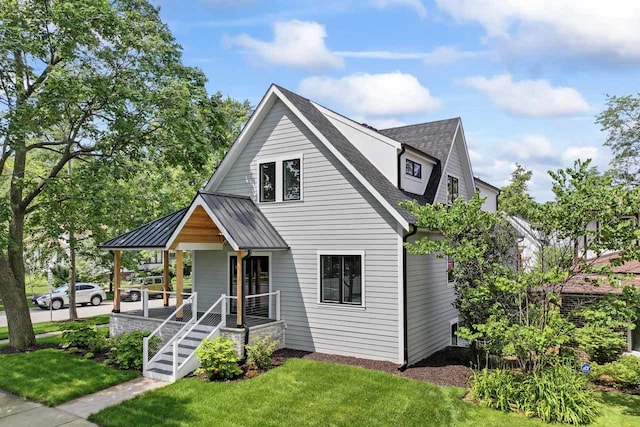 1100 Washington St, Glenview, IL 60025 - view of front facade featuring a porch, a front yard, roof with shingles, a standing seam roof, and a metal roof