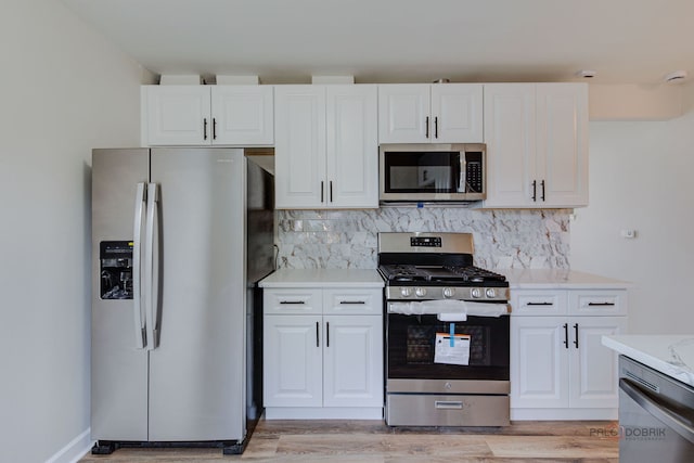 4603 Main St Unit B, Skokie, IL 60076 - kitchen featuring stainless steel appliances, decorative backsplash, light wood-type flooring, and white cabinetry