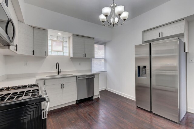 1825 S 8th Ave, Maywood, IL 60153 - kitchen featuring appliances with stainless steel finishes, dark wood-style floors, light countertops, a chandelier, and hanging light fixtures