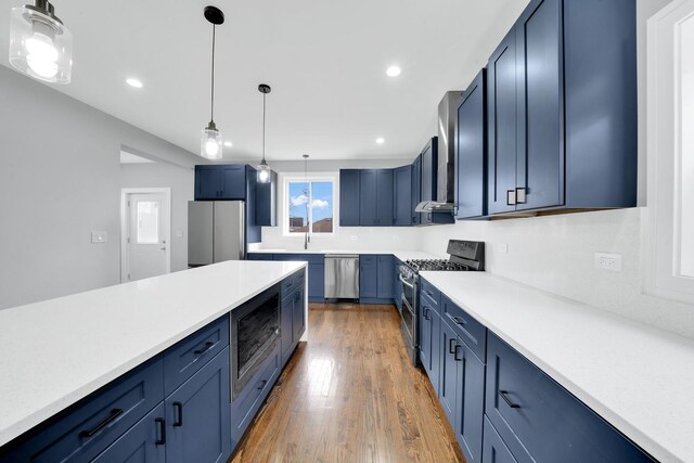 2613 Kenilworth Ave, Berwyn, IL 60402 - kitchen featuring appliances with stainless steel finishes, blue cabinets, decorative light fixtures, light countertops, and light wood-type flooring
