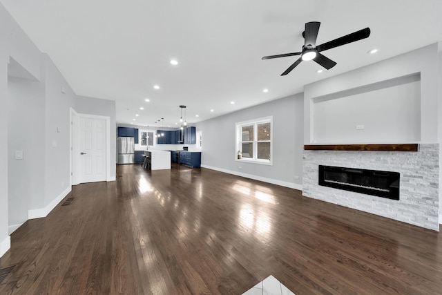 2613 Kenilworth Ave, Berwyn, IL 60402 - unfurnished living room featuring a stone fireplace, dark wood finished floors, a ceiling fan, and recessed lighting