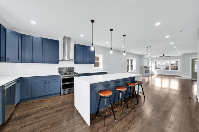 2613 Kenilworth Ave, Berwyn, IL 60402 - kitchen with double oven range, wall chimney range hood, blue cabinets, dark wood-style floors, and recessed lighting