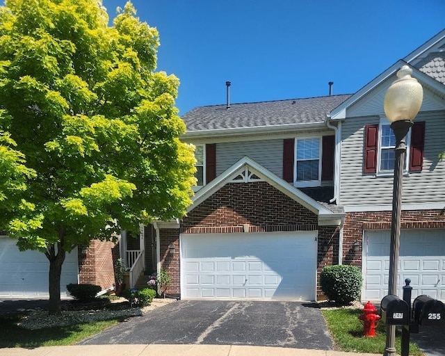 247 Lillian Ct, Geneva, IL 60134 - view of front of house with driveway, brick siding, and a garage