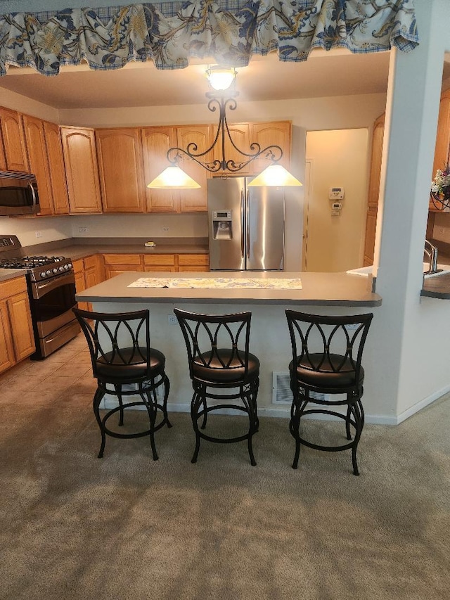 247 Lillian Ct, Geneva, IL 60134 - kitchen with stainless steel appliances, a breakfast bar area, light carpet, and light countertops