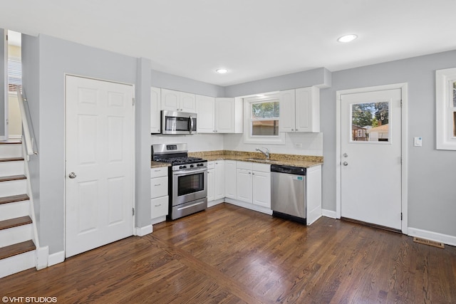 5051 Wright Ter, Skokie, IL 60077 - kitchen featuring appliances with stainless steel finishes, light stone countertops, dark wood-style floors, white cabinets, and recessed lighting