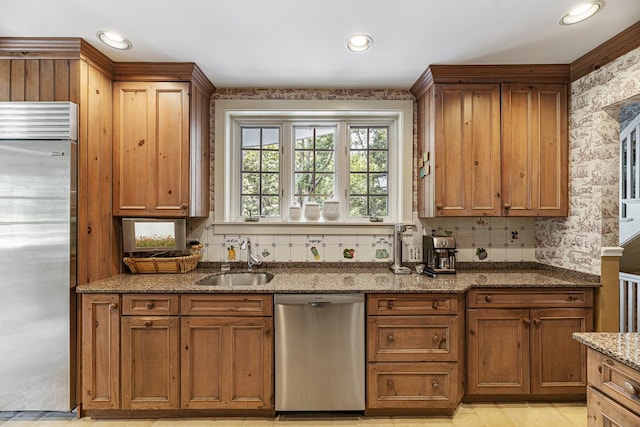 1755 Sunset Ln, Bannockburn, IL 60015 - kitchen featuring appliances with stainless steel finishes, wallpapered walls, stone counters, brown cabinetry, and recessed lighting
