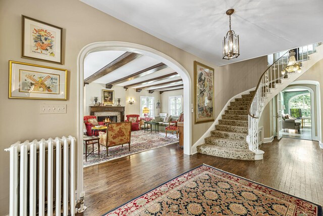 1755 Sunset Ln, Bannockburn, IL 60015 - entryway featuring radiator, arched walkways, hardwood / wood-style floors, plenty of natural light, and beam ceiling