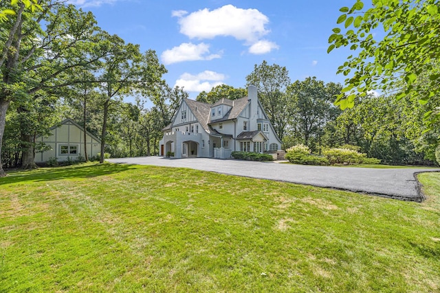 1755 Sunset Ln, Bannockburn, IL 60015 - tudor house with a chimney, a front yard, and driveway