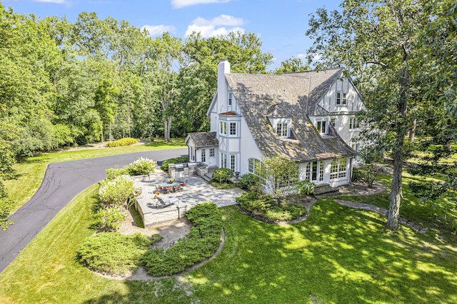 1755 Sunset Ln, Bannockburn, IL 60015 - view of side of home featuring a patio area, a lawn, a chimney, and french doors