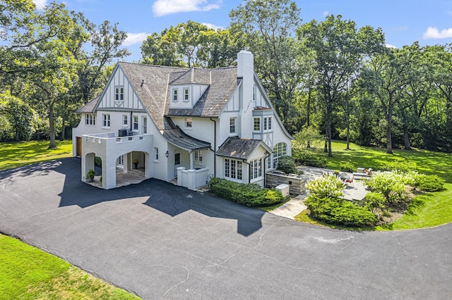1755 Sunset Ln, Bannockburn, IL 60015 - view of front of house featuring a chimney, an attached garage, asphalt driveway, stucco siding, and view of scattered trees