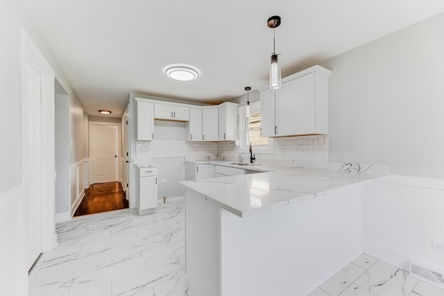 422 W 98th Pl, Chicago, IL 60628 - kitchen featuring a peninsula, light marble finish flooring, light stone counters, backsplash, and hanging light fixtures