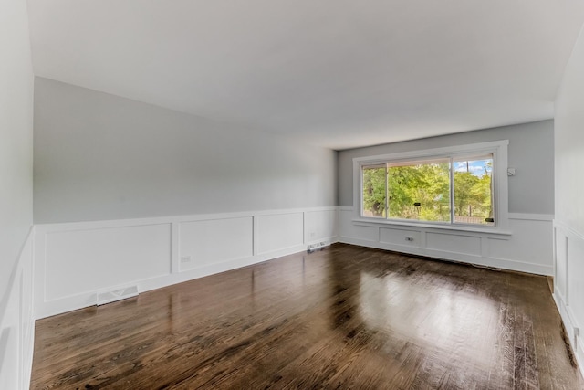 422 W 98th Pl, Chicago, IL 60628 - spare room featuring a wainscoted wall, dark wood-style flooring, and a decorative wall