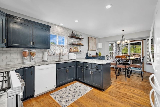 2570 Cobblestone Ct, Morris, IL 60450 - kitchen with dishwasher, a peninsula, tasteful backsplash, a chandelier, and light wood-style flooring