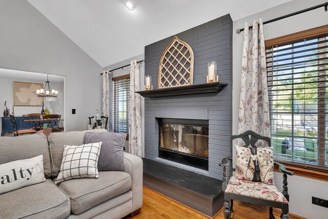 2570 Cobblestone Ct, Morris, IL 60450 - living area with a brick fireplace, a chandelier, wood finished floors, and high vaulted ceiling