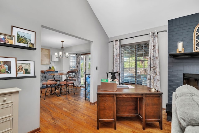 2570 Cobblestone Ct, Morris, IL 60450 - office space featuring light wood-style floors, a chandelier, high vaulted ceiling, and a brick fireplace