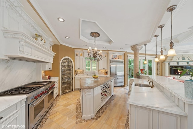 1031 Barrys Ct, Lake Forest, IL 60045 - kitchen with premium appliances, a spacious island, a tray ceiling, a chandelier, and tasteful backsplash